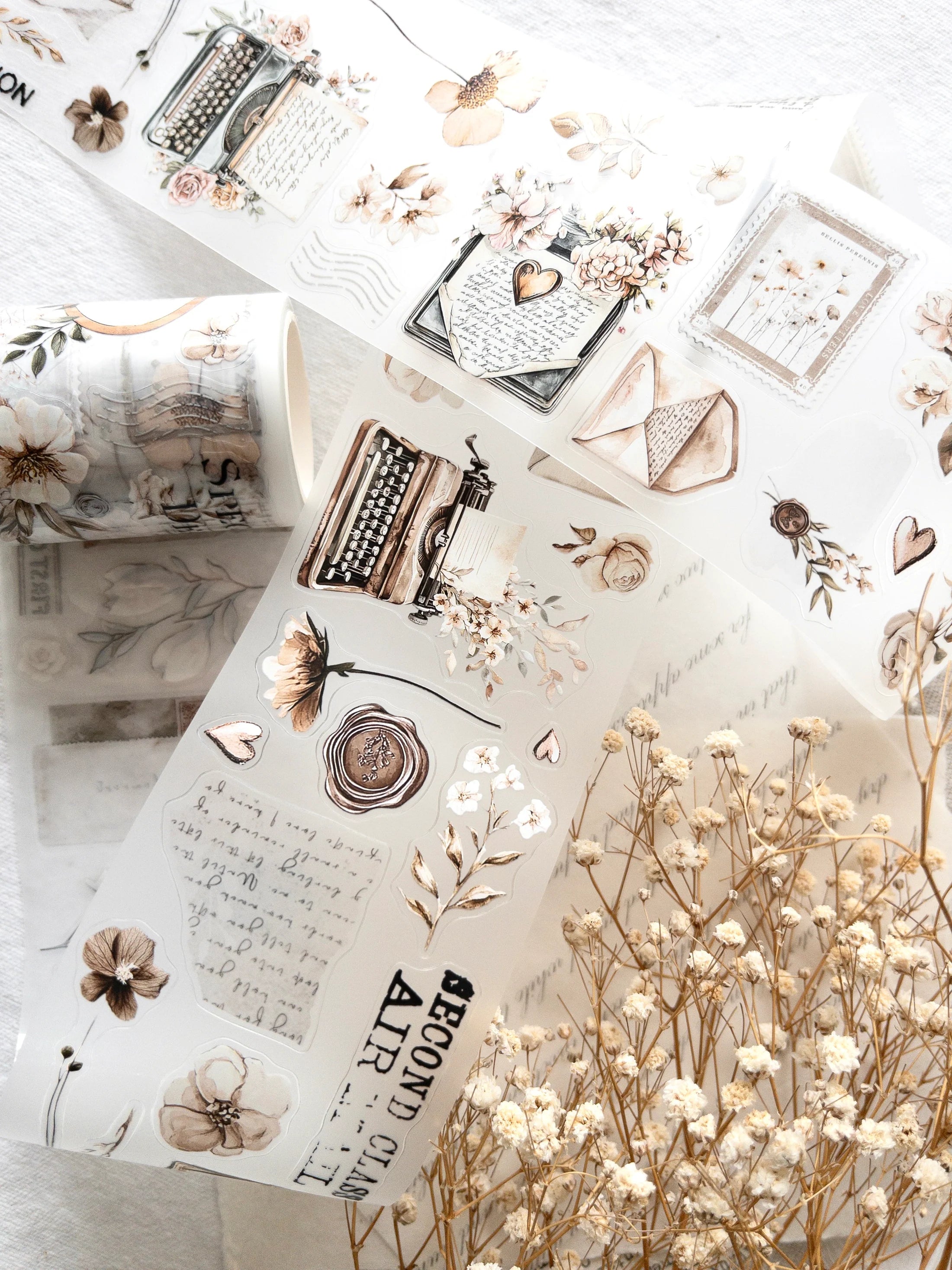 Decorative stickers with typewriter and flower designs on a white surface.