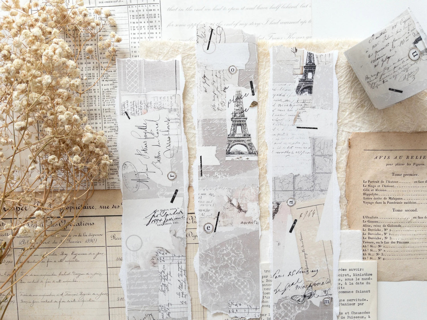 Decorative washi tape with vintage designs, particularly focus the Eiffel Tower, on a white surface with dried flowers.