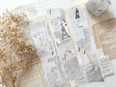 Decorative washi tape with vintage designs on a white surface with dried flowers.
