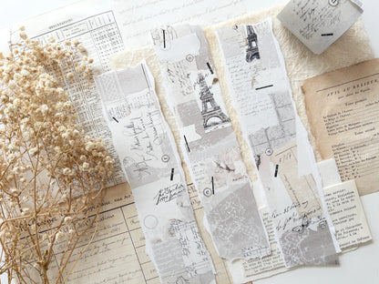 Decorative washi tape with vintage designs on a white surface with dried flowers.
