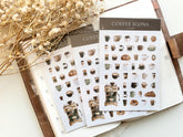 Sheets of coffee-themed mini stickers on a light surface with dried flowers.