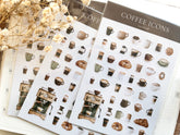 Sheets of coffee-themed mini stickers on a light surface with dried flowers.