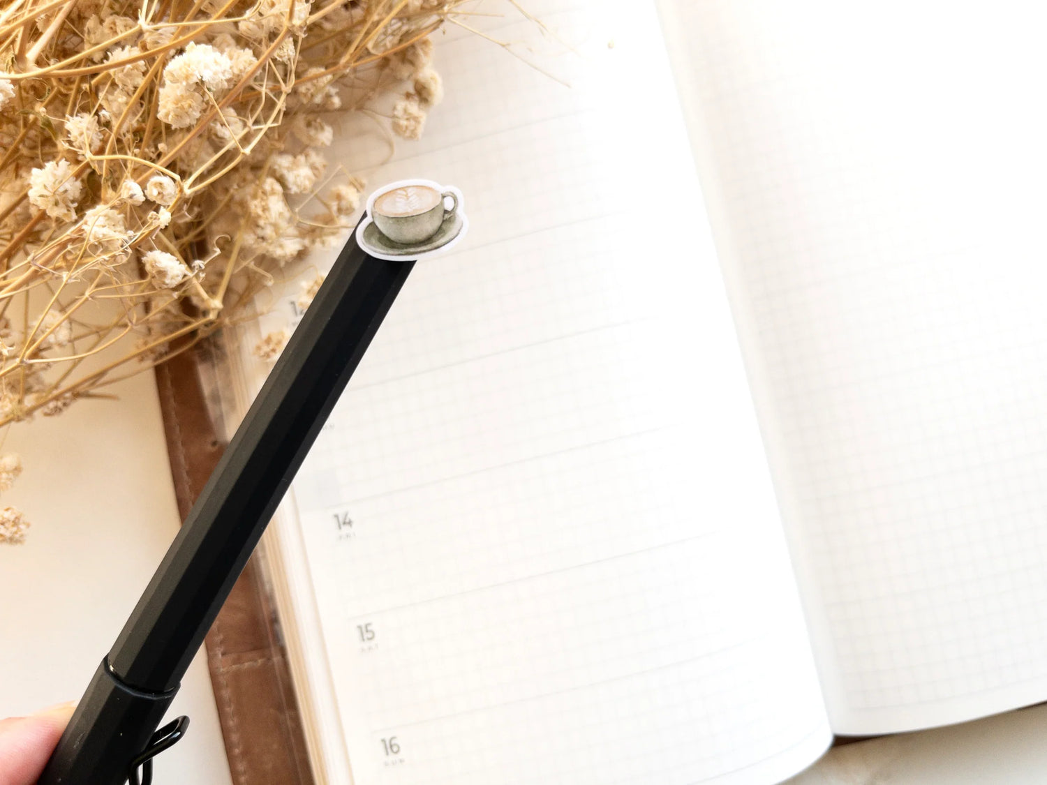 Black pen with a mini coffee icon sticker on the end.