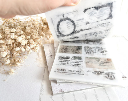 Hand flipping through sticker book with vintage-style designs on a light background