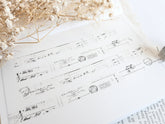 Washi tape with distressed vintage elements on light background with dried flowers next to it
