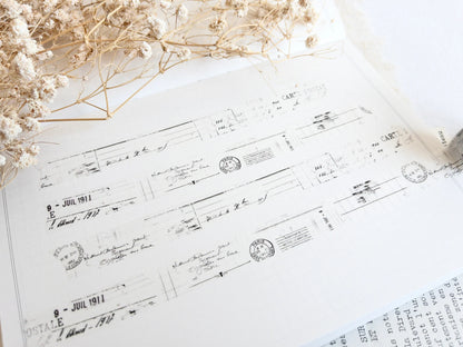 Washi tape with distressed vintage elements on light background with dried flowers next to it