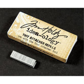 Box of Tim Holtz Idea-ology Tiny Attacher Refills on a black background