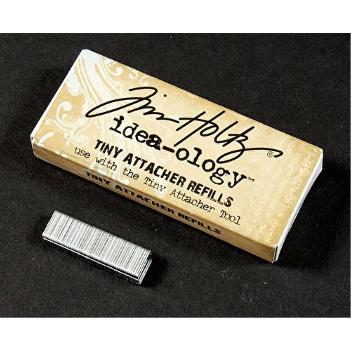 Box of Tim Holtz Idea-ology Tiny Attacher Refills on a black background