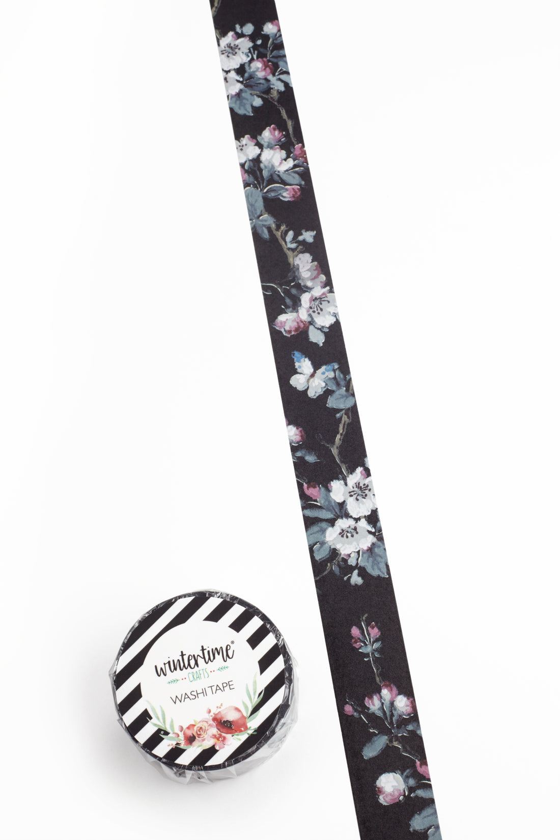 A roll of washi tape with a black background and a delicate floral pattern in pink, white, and green, shown next to its circular black-and-white striped label.