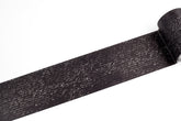 A roll of black tape with a white cursive handwriting, shown partially unrolled on a plain white background.