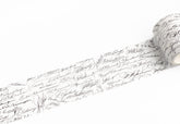 A roll of white adhesive tape featuring a black cursive script pattern, shown partially unrolled on a clean white background.