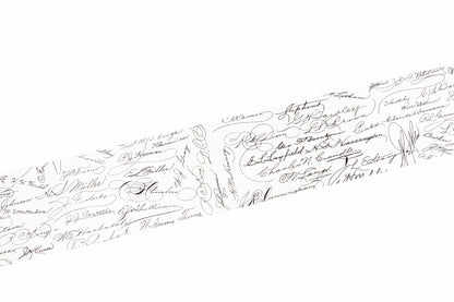 A close-up of a white washi tape covered with many small black handwritten signatures and cursive writing, shown diagonally across the frame.
