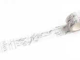 A roll of white washi tape with a black cursive script and grid pattern, shown partially unrolled on a clean white background.