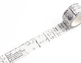 A roll of decorative washi tape with a vintage French script and postmark pattern, partially unrolled on a clean white background.