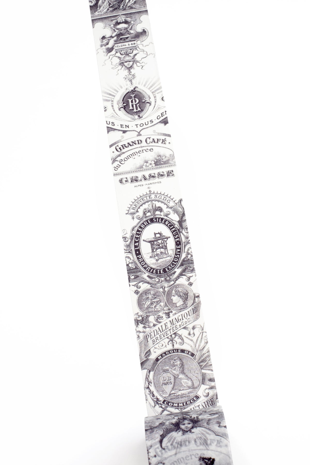 A long washi strip with a repeating black vintage-style ornamental pattern and text, shown against a plain white background.