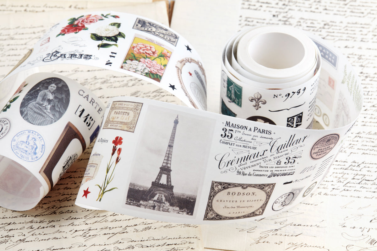 Washi tape with pre-cut vintage-style decorative stickers such as illustrated labels, postage stamps, numbers, and antique typography, laid over a background of old handwritten letters and papers.