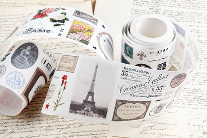 Washi tape with pre-cut vintage-style decorative stickers such as illustrated labels, postage stamps, numbers, and antique typography, laid over a background of old handwritten letters and papers.