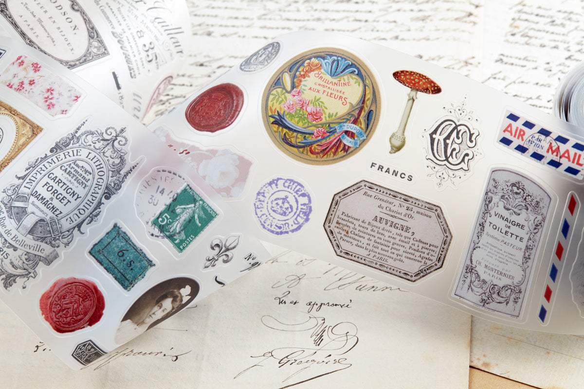 PET tape with pre-cut vintage-style decorative stickers such as illustrated labels, postage stamps, numbers, and antique typography, laid over a background of old handwritten letters and papers.