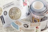 PET tape with pre-cut vintage-style decorative stickers such as illustrated labels, postage stamps, numbers, and antique typography, laid over a background of old handwritten letters and papers.
