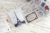 PET tape with pre-cut vintage-style decorative stickers such as illustrated labels, postage stamps, numbers, and antique typography, laid over a background of old handwritten letters and papers.