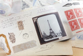 PET tape with pre-cut vintage-style decorative stickers such as illustrated labels, postage stamps, numbers, and antique typography, laid over a background of old handwritten letters and papers.