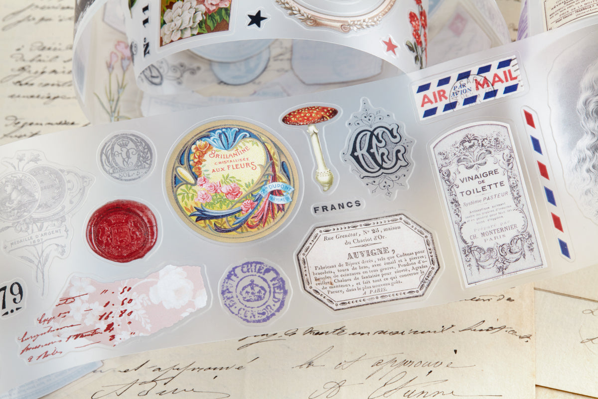 PET tape with pre-cut vintage-style decorative stickers such as illustrated labels, postage stamps, numbers, and antique typography, laid over a background of old handwritten letters and papers.