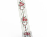A close-up of a decorative wasi tape featuring a repeating vertical floral pattern with red flowers, green leaves, and dotted lines, shown against a plain white background.