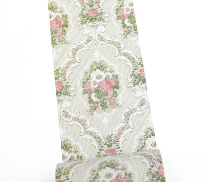 A roll of washi tape featuring a vintage damask pattern with pink roses, green leaves, and white scrollwork on a light beige striped background.