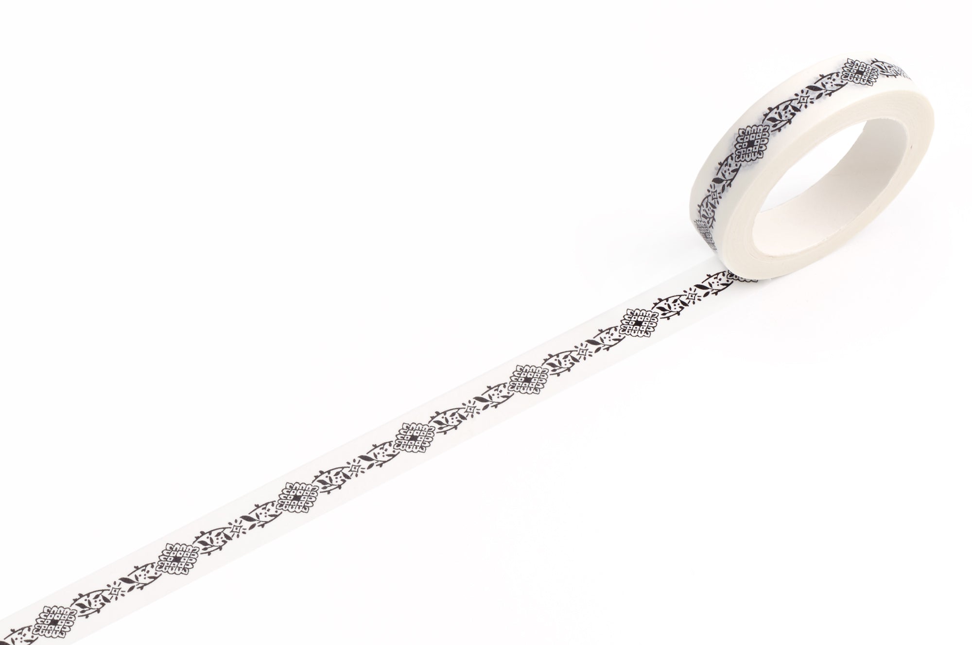 A roll of white decorative tape with a repeating black filigree pattern, shown unrolled on a clean white background.