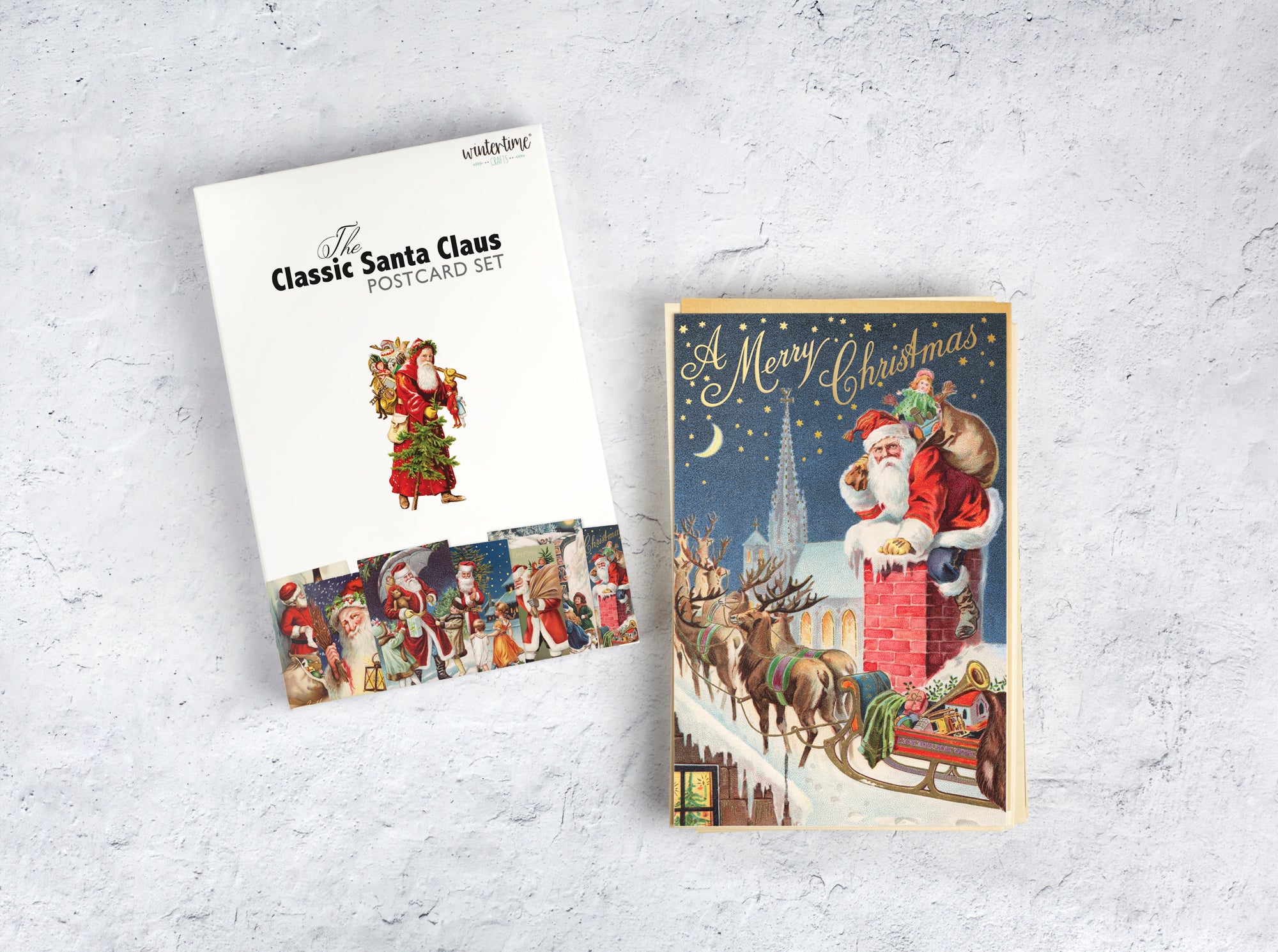 A Christmas postcard set displayed on a light gray textured surface, featuring a white box labeled &