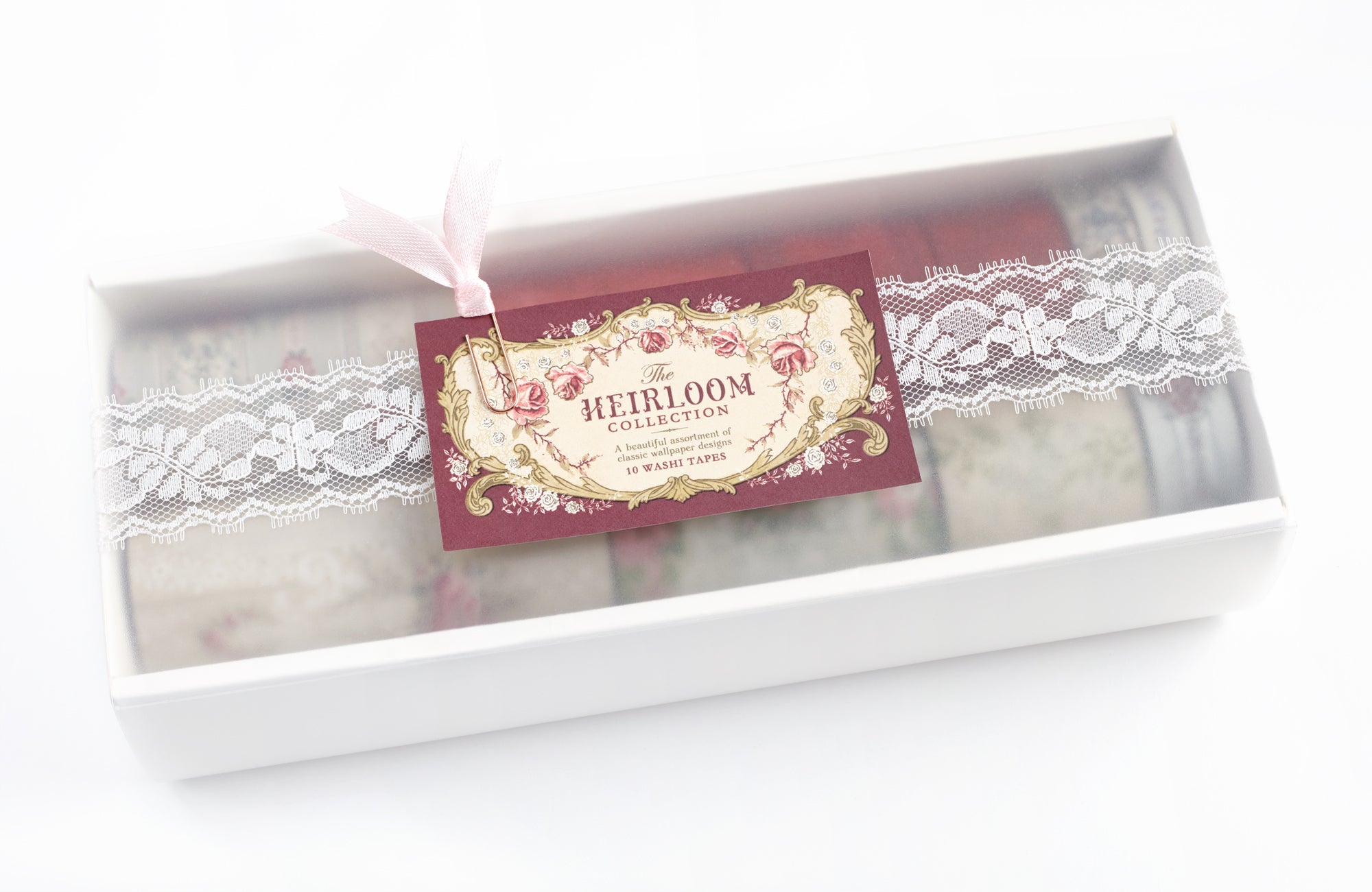 A boxed set of vintage-style washi tapes from The Heirloom Collection, featuring white lace-patterned tapes and a deep red tape, presented in a white gift box with a decorative tag.