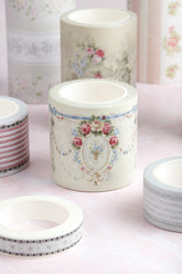 A collection of decorative washi tapes with vintage floral and striped patterns, displayed on a soft pink surface.